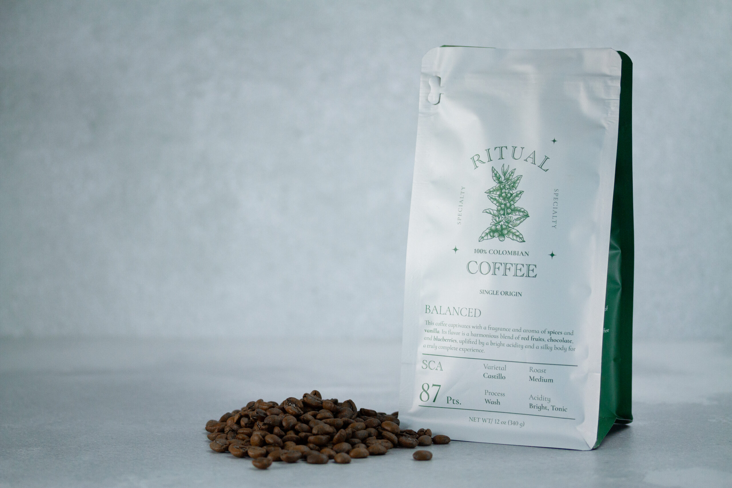 Ritual Balanced coffee bag beside a pile of roasted coffee beans