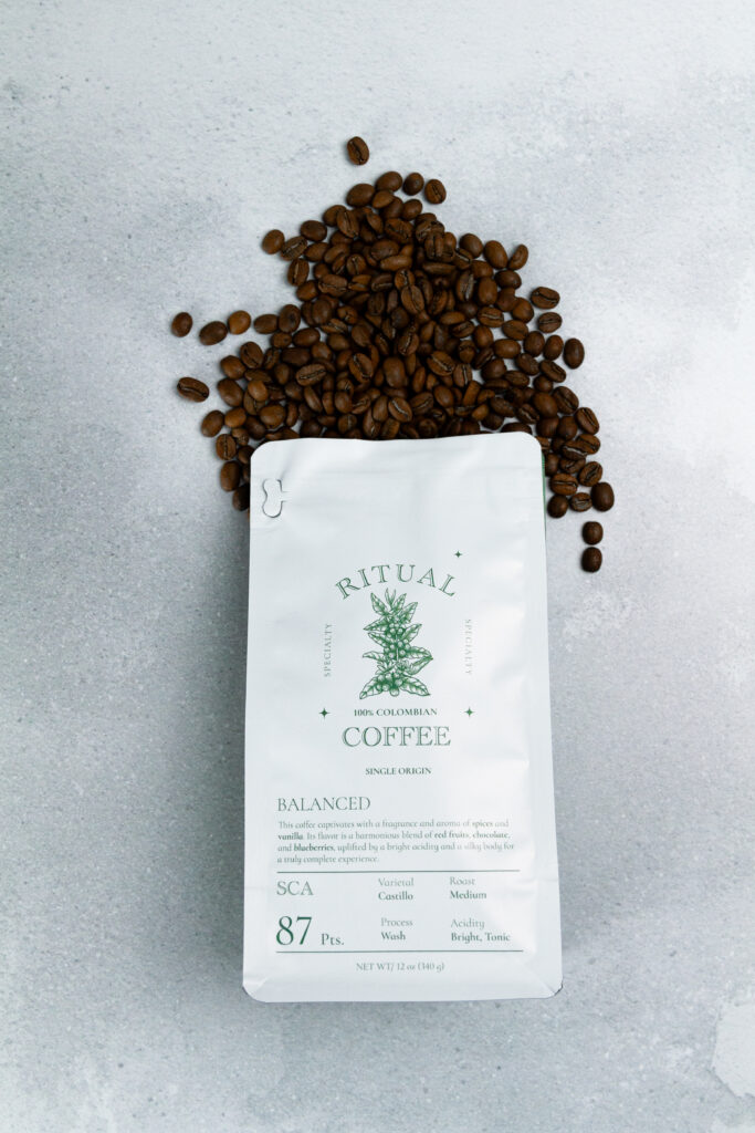 Ritual Balanced coffee bag under a scatter of roasted coffee beans