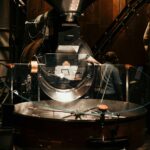 Coffee roaster in a roastery with beans in the cooling tray