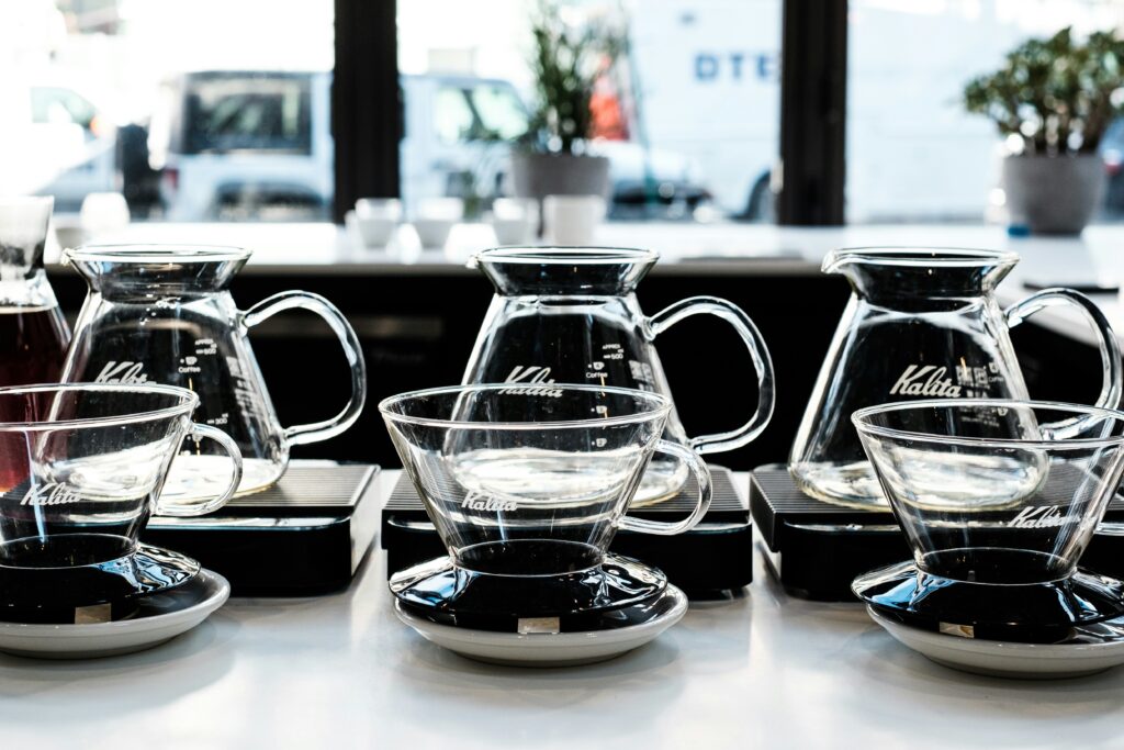 Row of glass coffee servers on scales at a cafe brew bar
