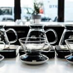 Row of glass coffee servers on scales at a cafe brew bar