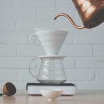 Pour-over coffee brewing with a copper gooseneck kettle and white dripper