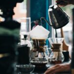 Barista pouring water from a gooseneck kettle at a pour-over bar