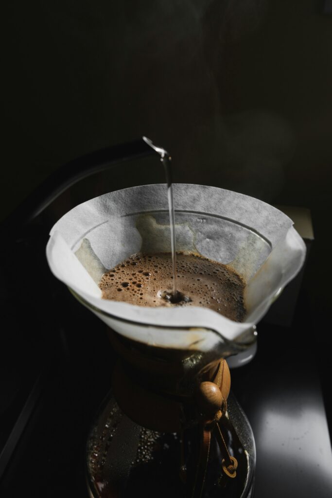 Hot water pouring into a pour-over filter over a glass carafe