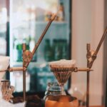 Pour-over coffee brewing on copper stands in a cafe