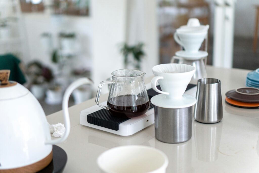 Pour-over coffee setup with kettle, scale, dripper and server on a table
