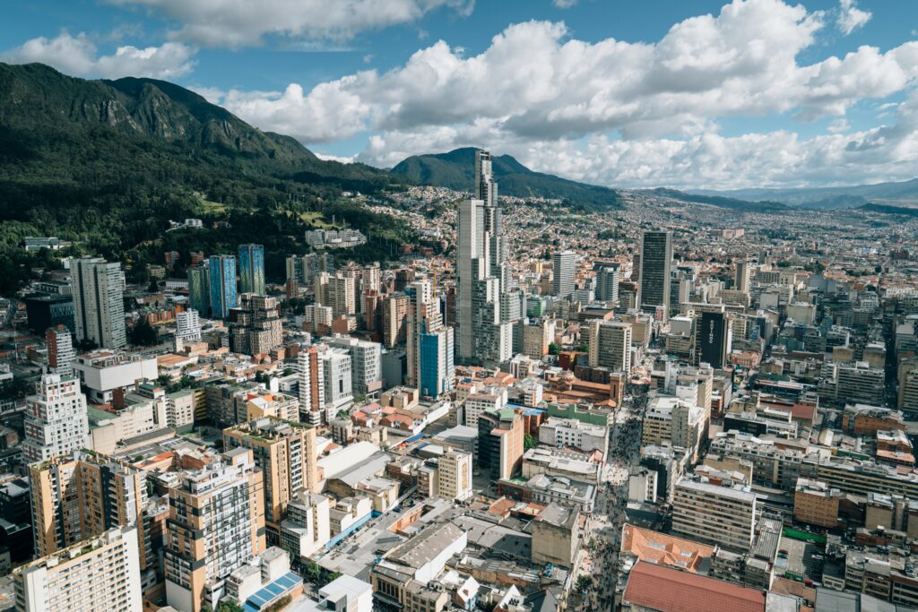 Aerial view of a city skyline in front of green mountains